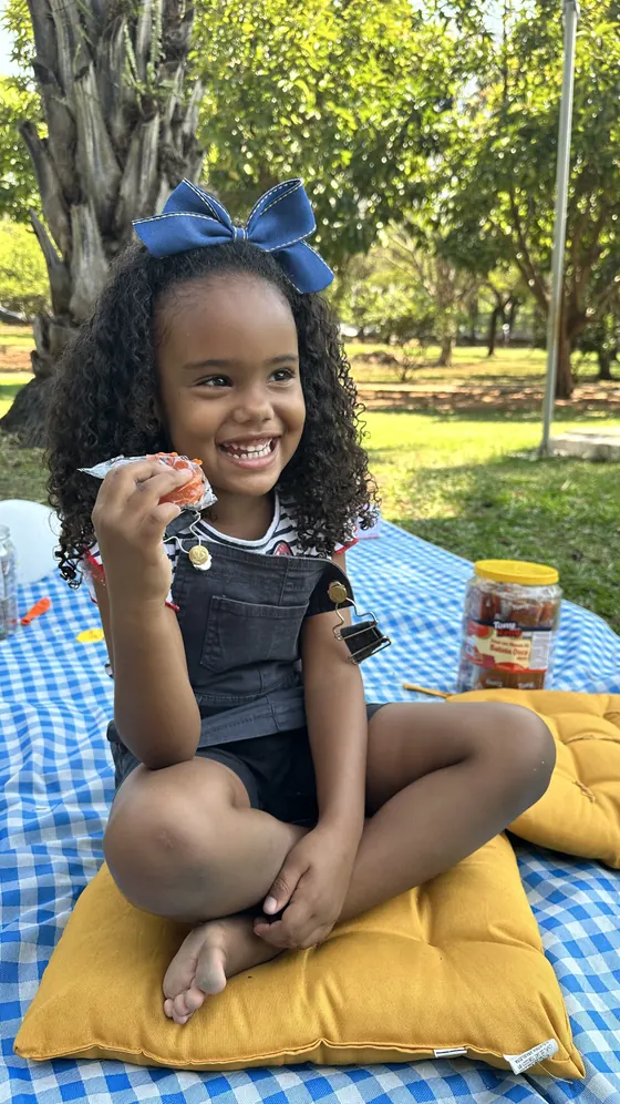Menina sorrindo com um doce Tony Kelly