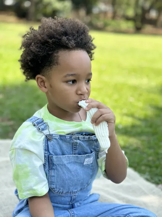 Menino comendo um doce Tony Kelly no piquenique